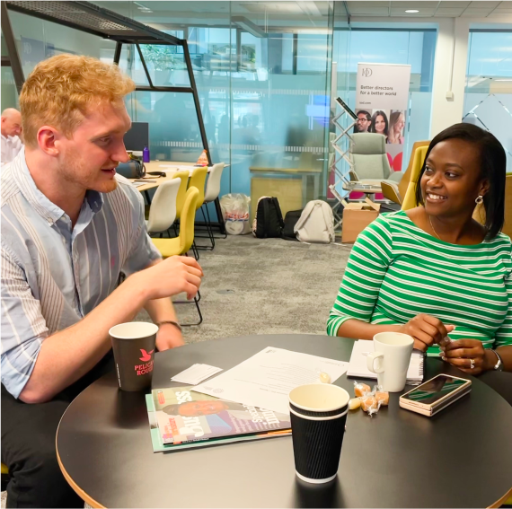 A photo of a man and a woman in conversation over a table at The Knowledge Exchange Hub facility at Leeds Beckett University