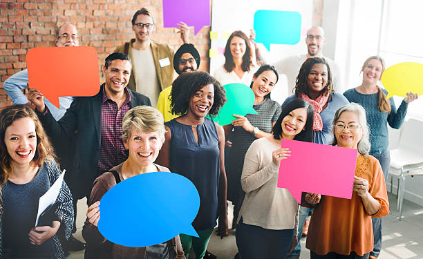 Diverse group of people standing together holding coloured speech bubbles