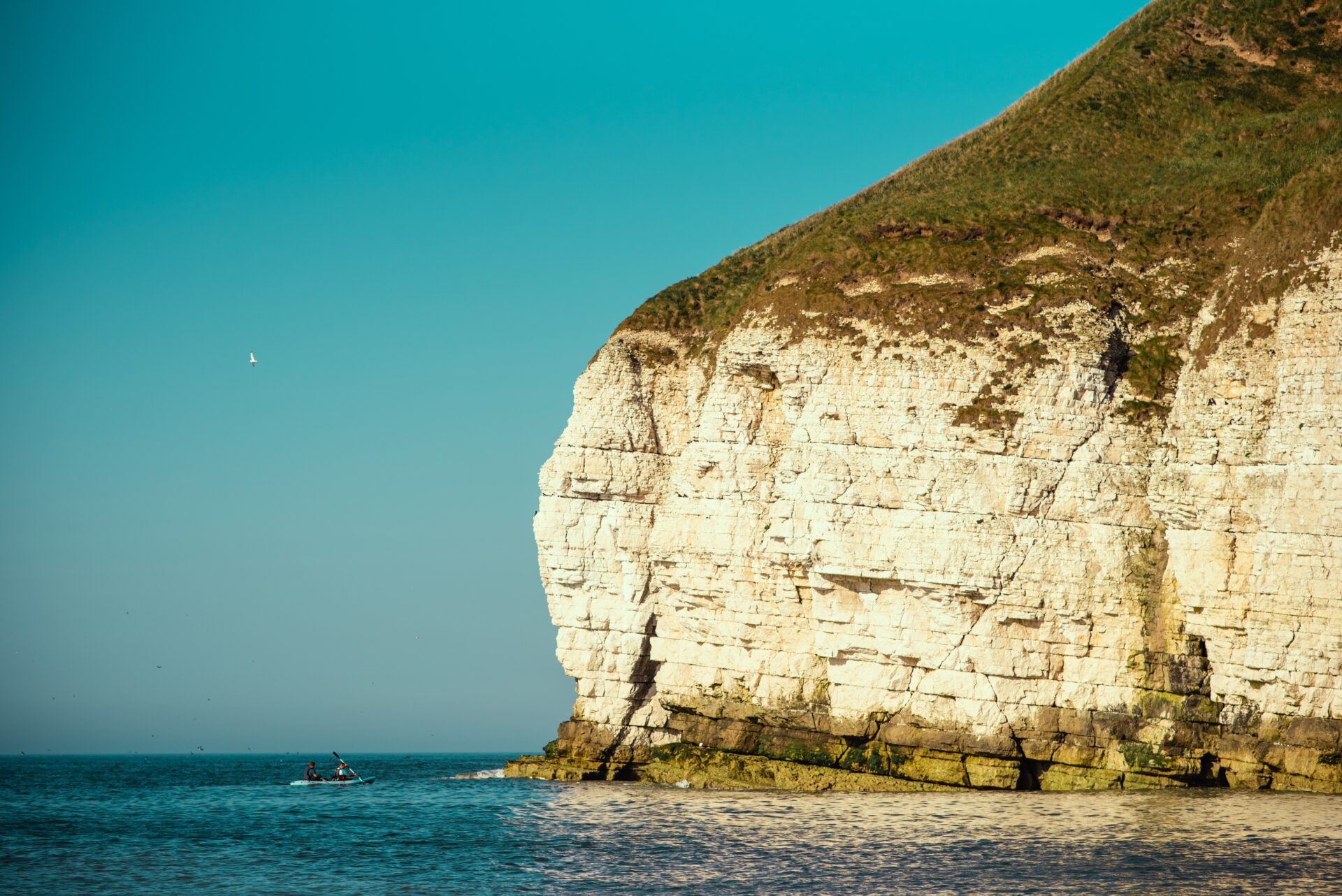 Picture of a cliff on the Bridlington coast on a sunny day. Kayaker underneath.